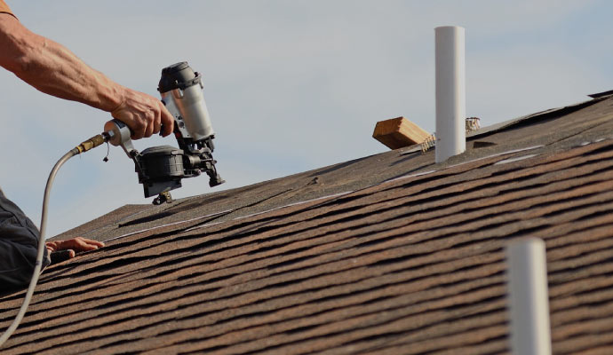 A person repairing a roof using equipment